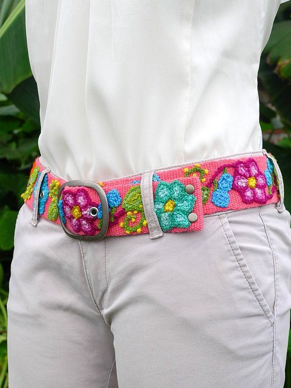 a woman in white shirt and pink belt with flowered design on the bottom half of her waist