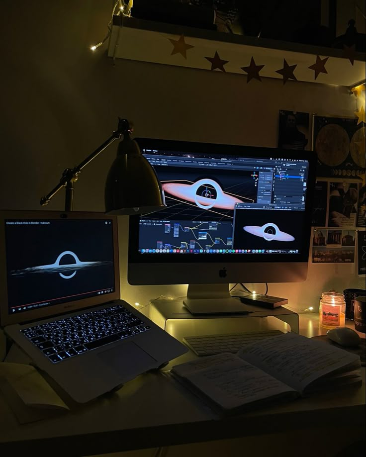 a desk with a laptop and computer monitor on it, lit up by the light of a lamp