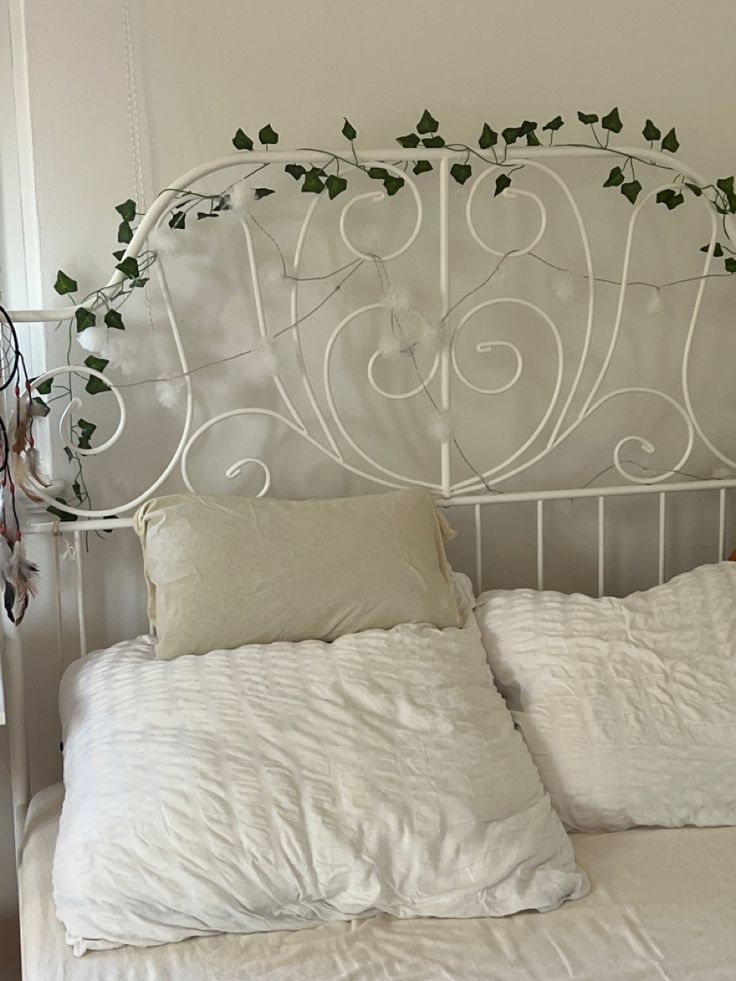 a white iron headboard with vines on it