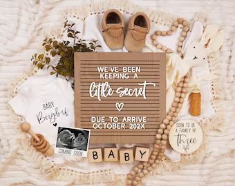 the baby announcement is surrounded by items such as shoes, beads and t - shirts