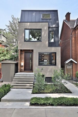 a modern house with stairs leading up to the front door