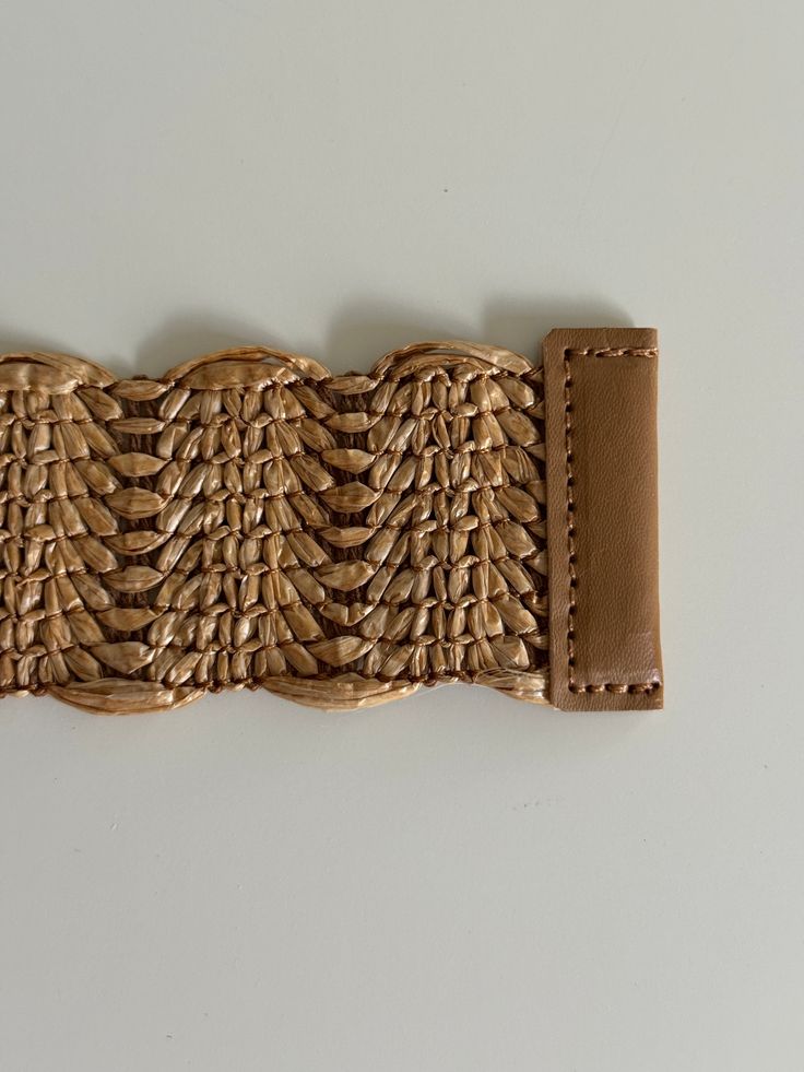 Enhance your wardrobe with our exquisite Woven Raffia Belt, featuring a stylish rattan buckle. This high-quality belt in a versatile tan color effortlessly coordinates with any outfit, making it a must-have accessory for every season. Lightweight yet durable, it provides the perfect blend of fashion and functionality. Whether you're dressing up for a special occasion or adding a chic touch to your casual attire, this belt is designed to complement your style beautifully. Embrace the natural eleg Beige Woven Belt For Vacation, Chic Woven Belts For Beach, Chic Woven Belts For The Beach, Chic Woven Belt For Beach, Beige Woven Belts For Spring, Spring Beige Woven Belt, Trendy Adjustable Brown Belt, Casual Adjustable Braided Belt, Spring Beige Rope Belt