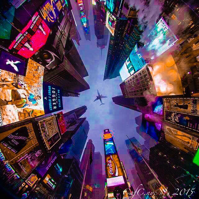 an airplane flying through the middle of a city filled with tall buildings and neon signs