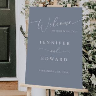 a welcome sign for a wedding in front of a door with greenery on it