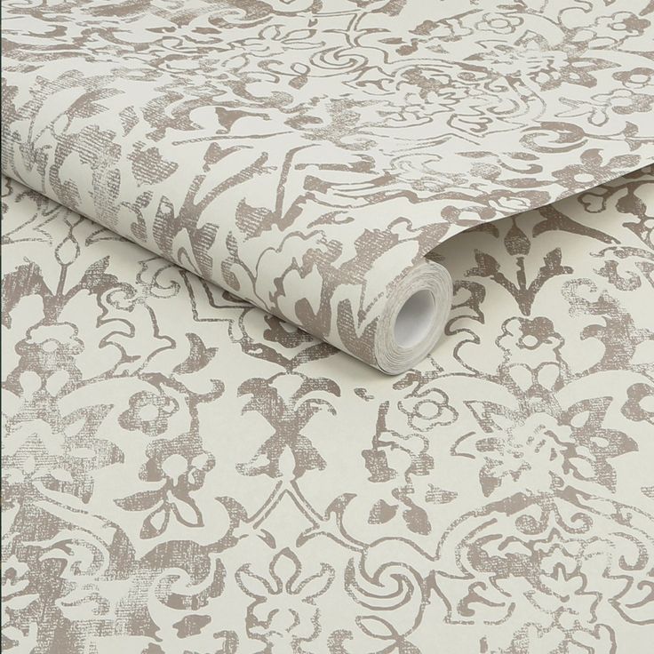 a white and brown wallpaper with an ornate design on it's surface,