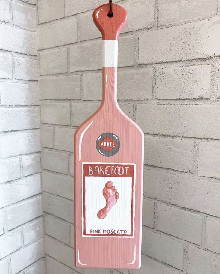 a pink bottle hanging from the side of a brick wall