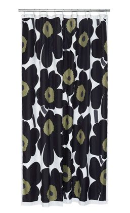 a black and white shower curtain with green flower print on it, hanging from a metal rod