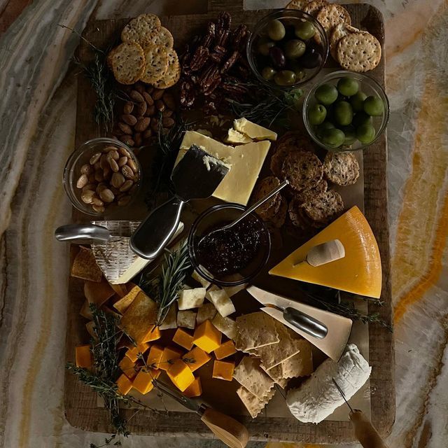 various cheeses and nuts are arranged on a tray