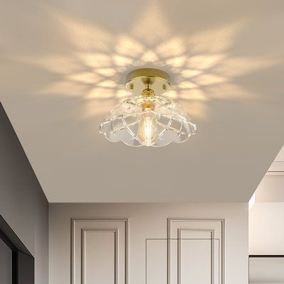 a bathroom with white walls and flooring has a ceiling light in the shape of a starburst