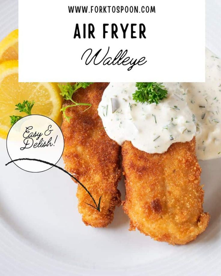 an air fryer meal on a white plate with lemon wedges and sour cream