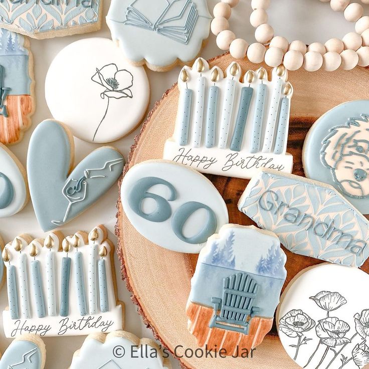 cookies decorated with frosting and icing are arranged on a wooden plate, surrounded by other cookie decorating items