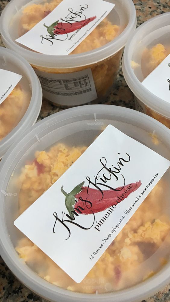 four plastic containers filled with food sitting on top of a granite counter topped with labels