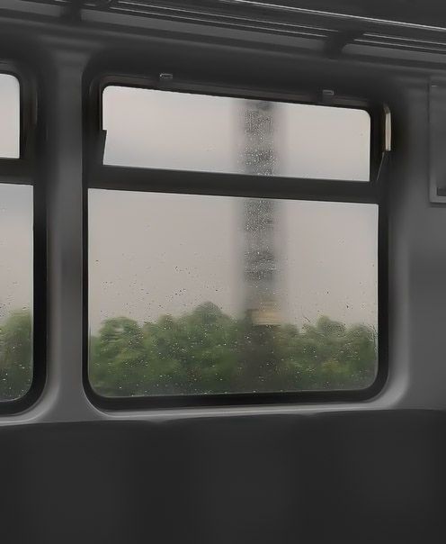 a view from the inside of a train looking out at trees and a tower in the distance