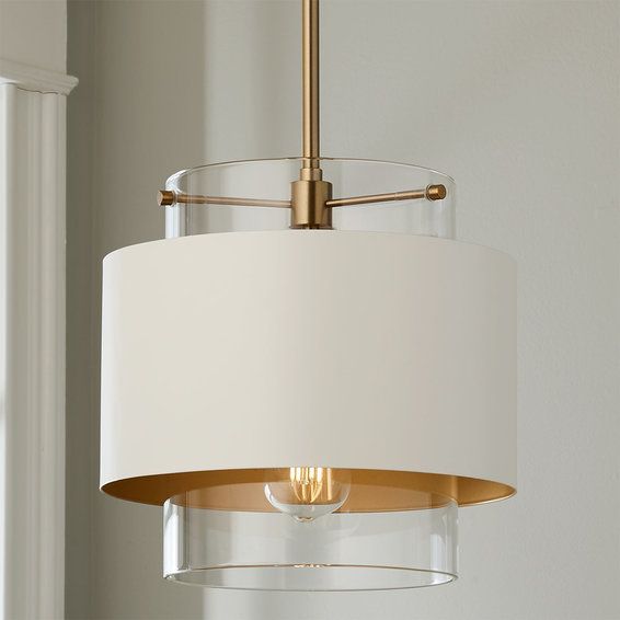 a light fixture with a white shade hanging from it's center point in a room