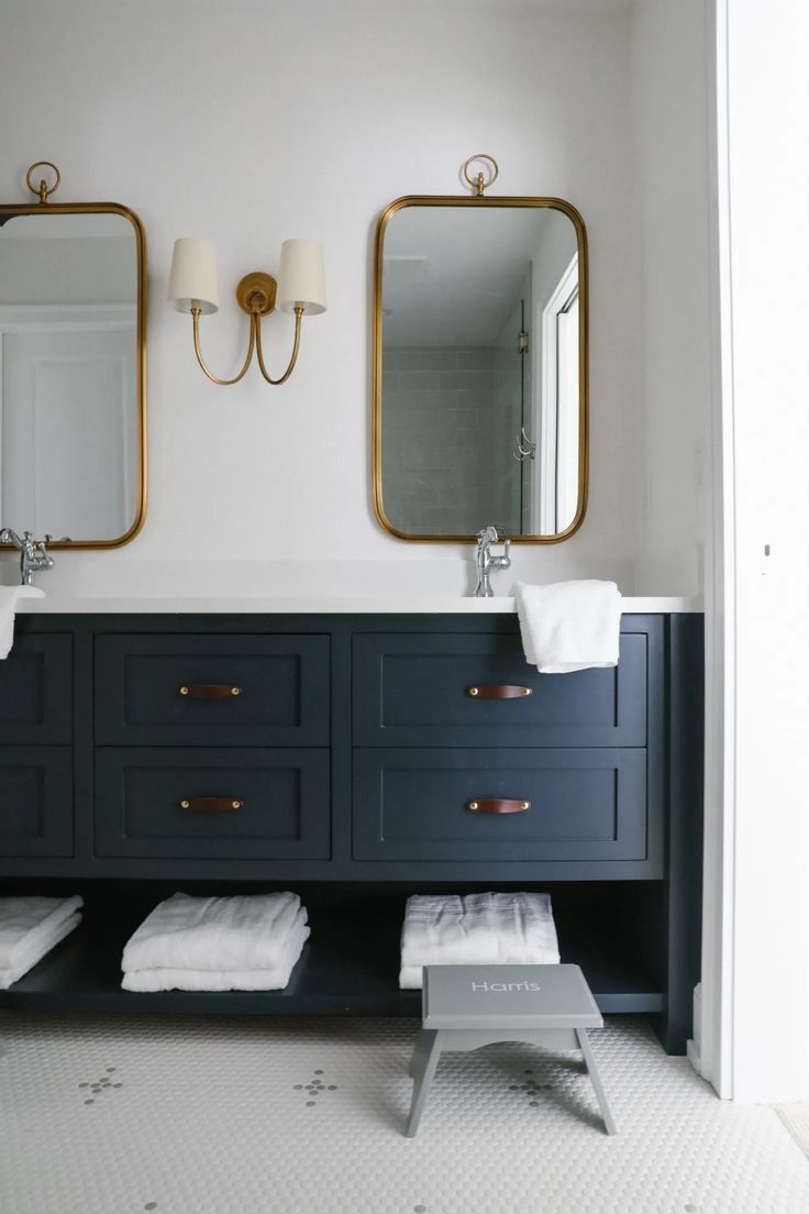 a bathroom with two sinks and mirrors on the wall