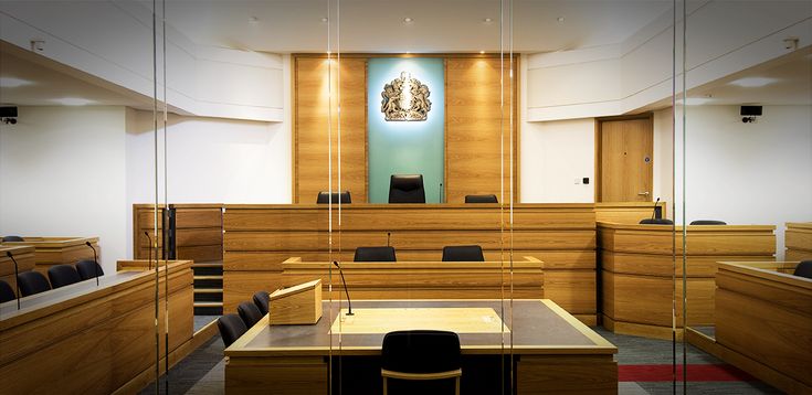 an empty courtroom with chairs and desks in front of the judge's bench