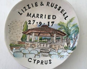 a white plate with a drawing of a gazebo and the words, little & russell married 27 / 19 / 17 cyprus