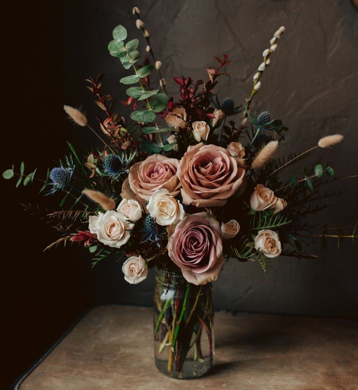 a vase filled with lots of flowers on top of a table