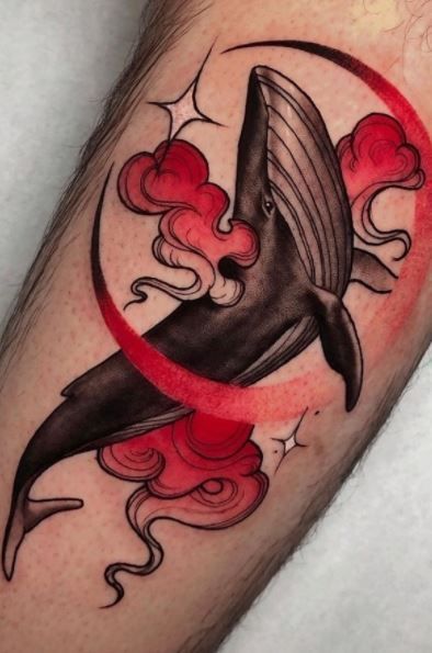 a tattoo with a whale on it's leg and red circles around the tail