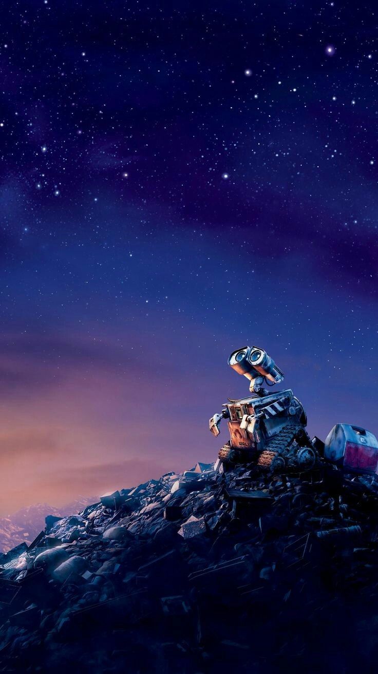 a man sitting on top of a pile of rocks under a night sky