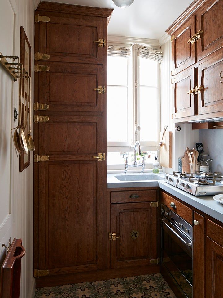 a kitchen with wooden cabinets and white counter tops, along with a window over the sink