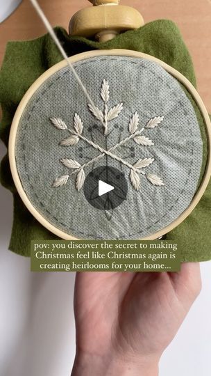 someone is holding up a cross stitch ornament to show how it's done