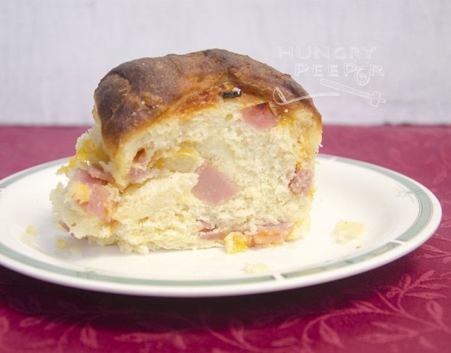 a piece of ham and cheese cake on a plate with a red tablecloth behind it