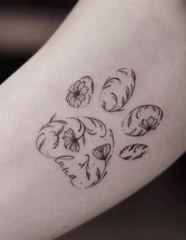 a black and white photo of a dog paw tattoo