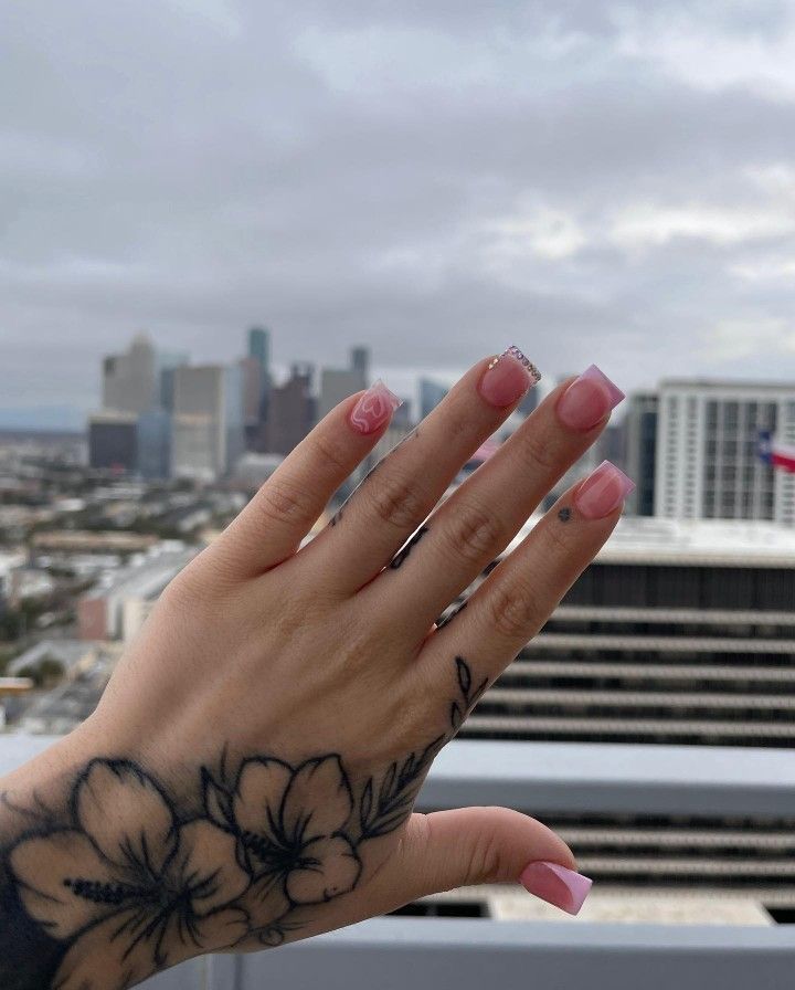 a woman's hand with a flower tattoo on it