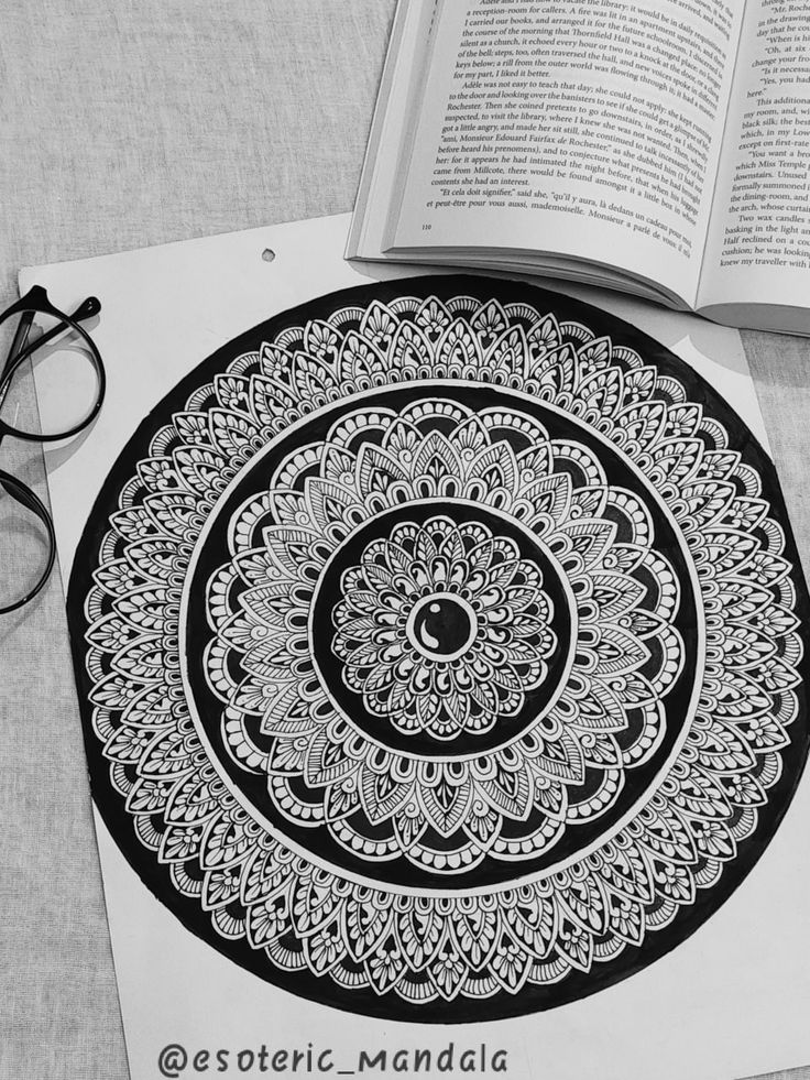 an open book sitting on top of a table next to glasses and eyeglasses