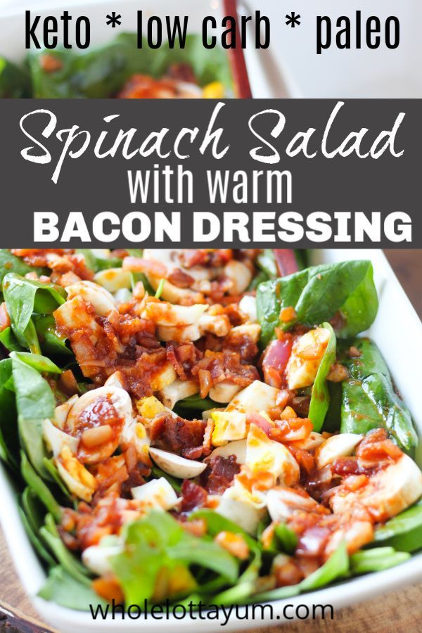 spinach salad with bacon dressing in a white dish