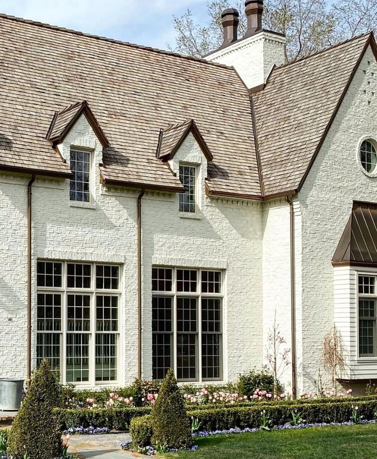 a white brick house with two chimneys and windows