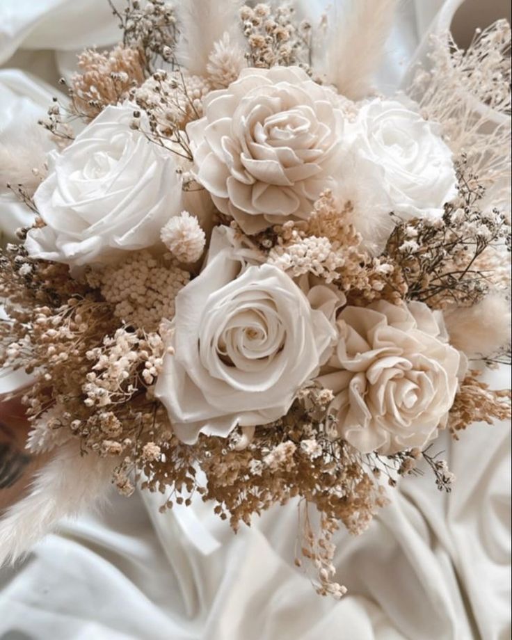 a bridal bouquet with white roses and feathers