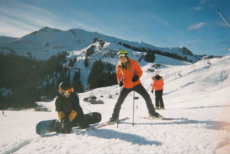 three people on skis and snowboards in the snow