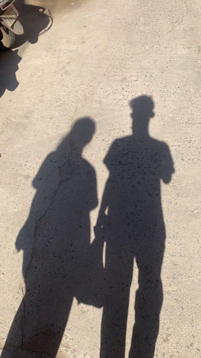 the shadow of two people standing next to each other