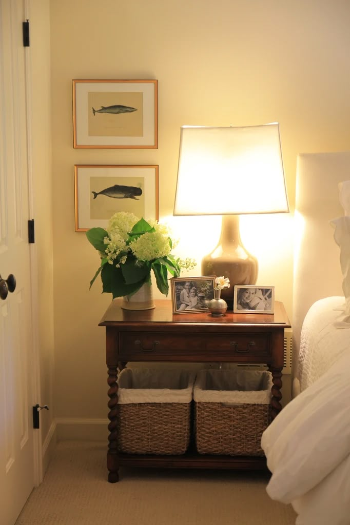 a bedroom with a bed, lamp and pictures on the wall