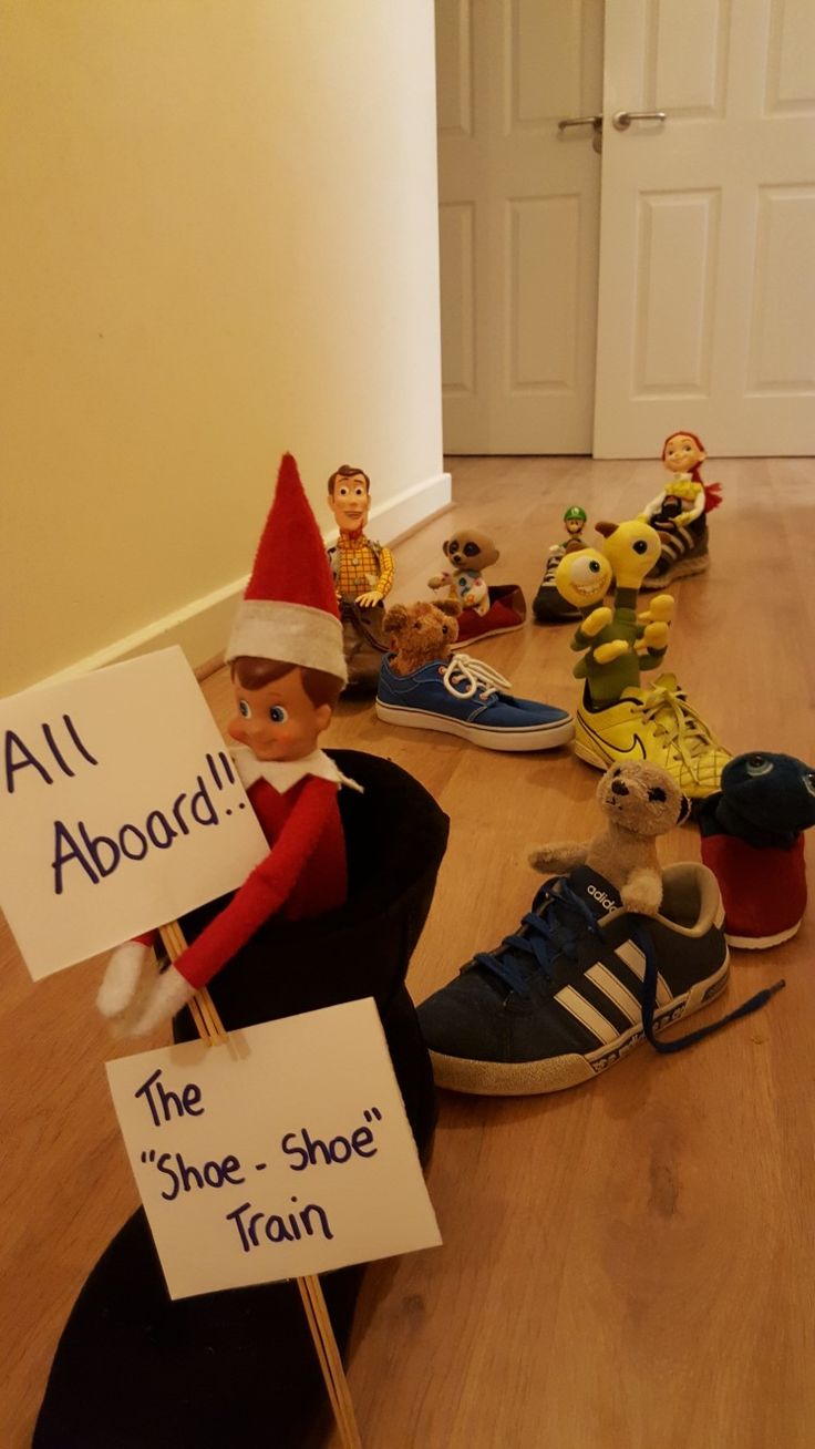 the elf is holding a sign in front of his face and several other toys on the floor