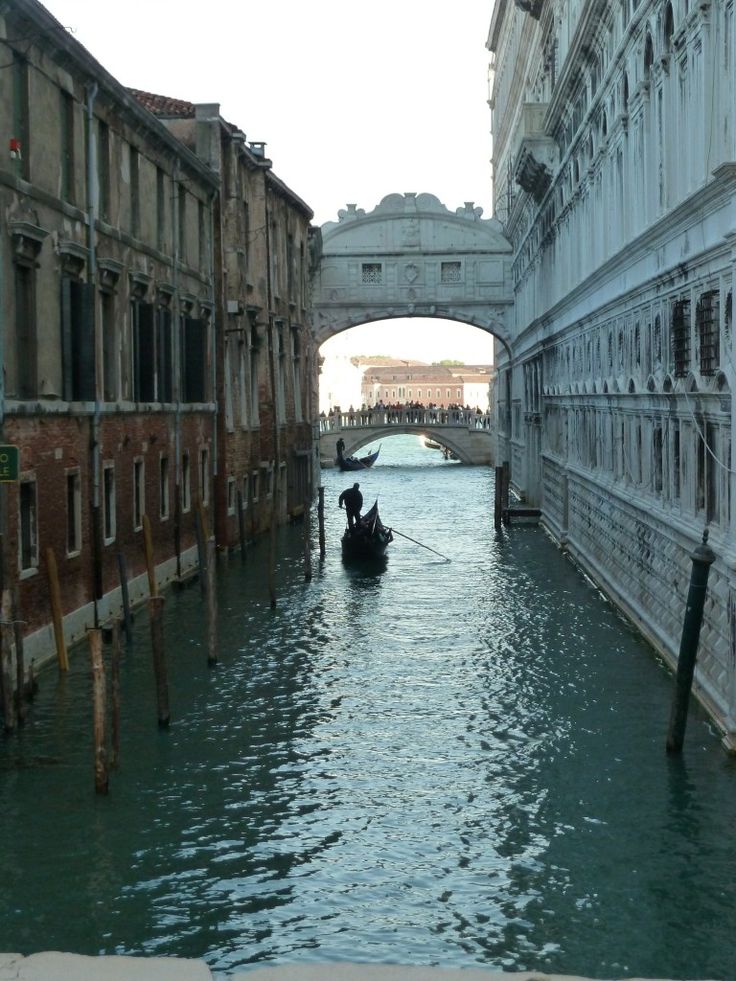 a gondola is moving down the canal under an overpass in venice, italy