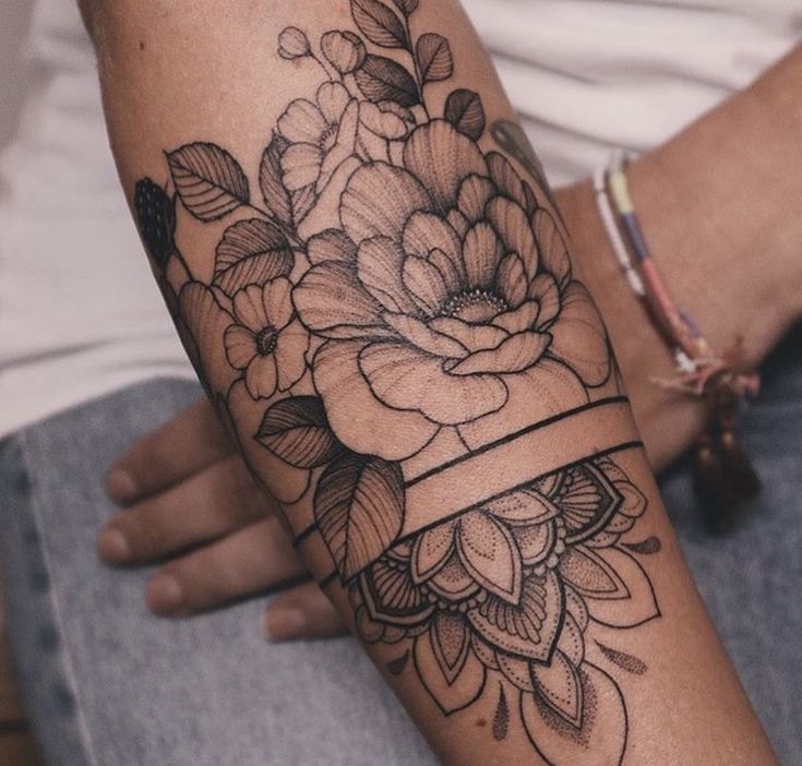 a woman's arm with flowers on it and a ribbon around the wrist that says cydrruc lilassol