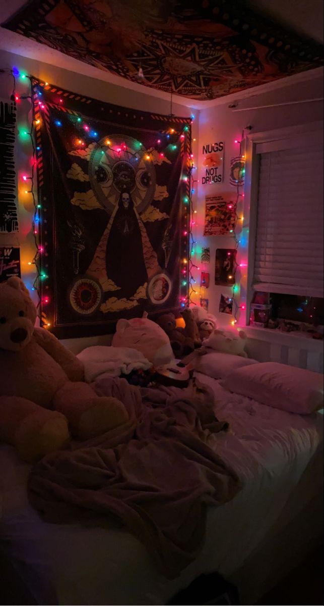 two teddy bears sitting on top of a bed in a room with lights all around