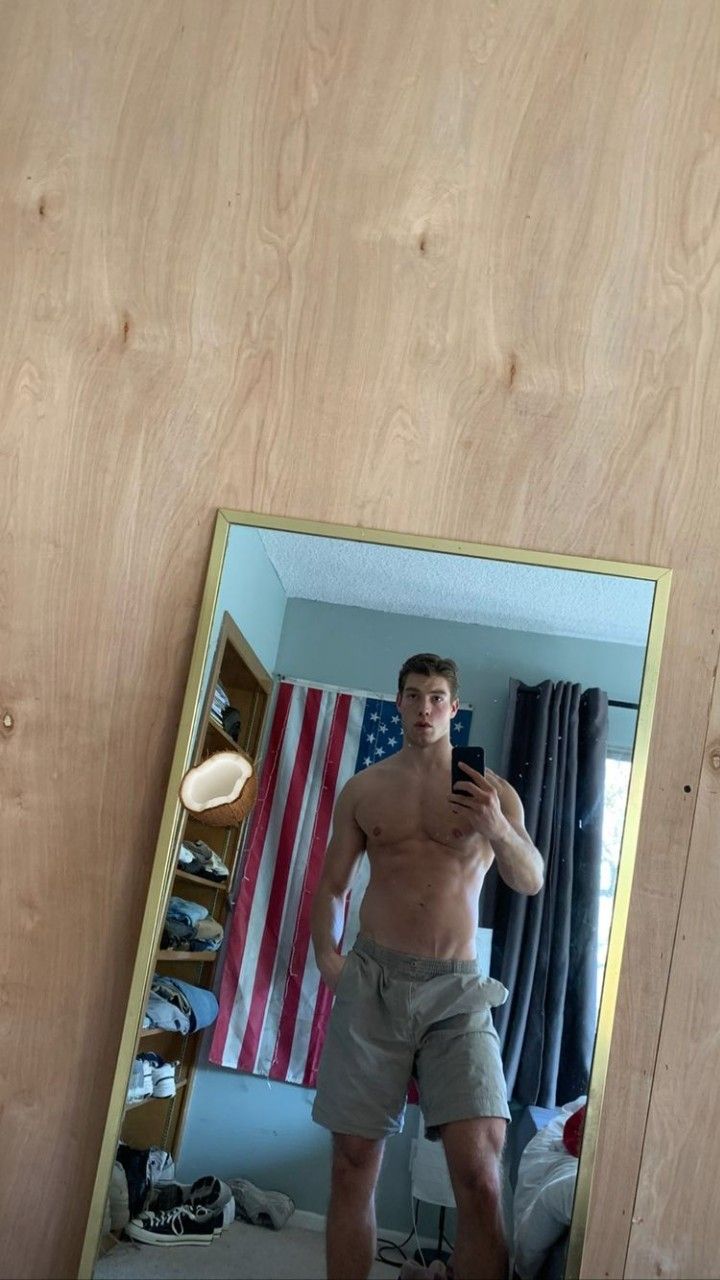 a man standing in front of a mirror taking a selfie