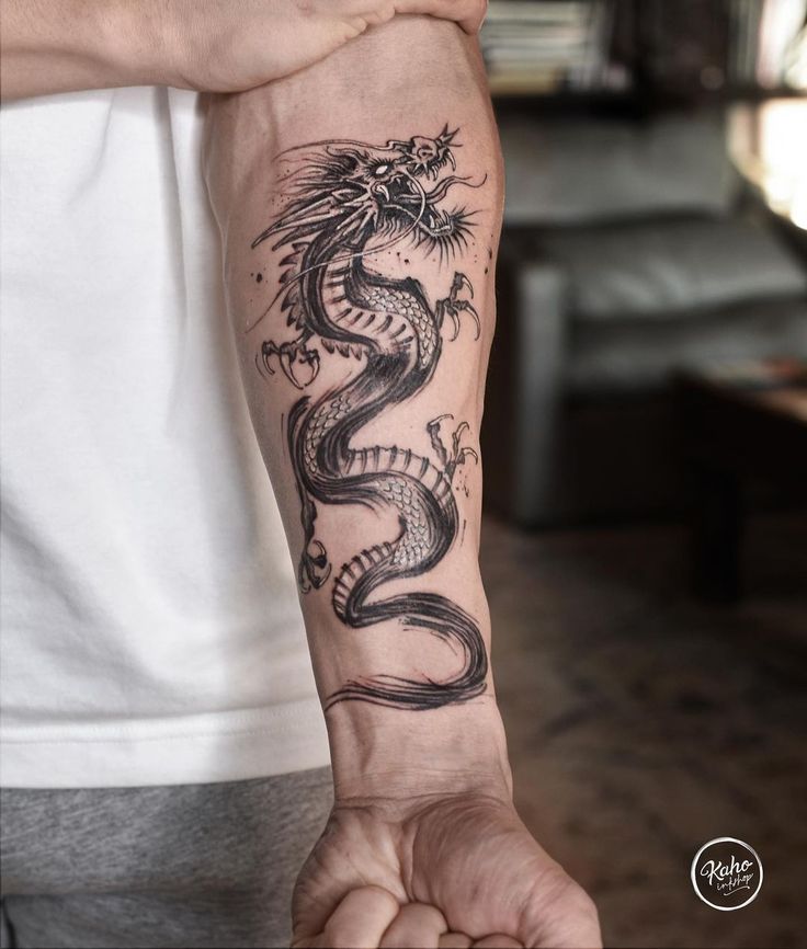 a man with a dragon tattoo on his arm holding onto the other side of his arm