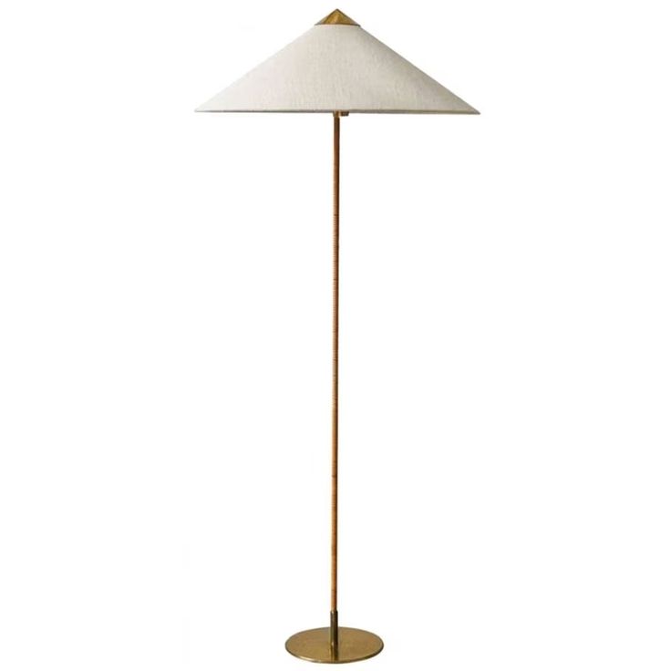 a floor lamp with a white shade on the top and a gold base, against a white background