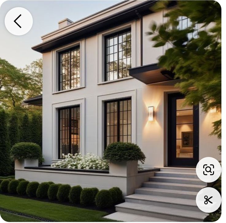 an image of a white house with black windows and steps leading up to the front door