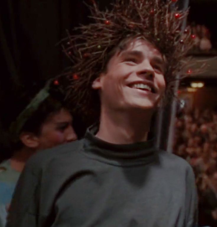 a young man with dreadlocks on his head smiles at the camera while standing in front of an audience