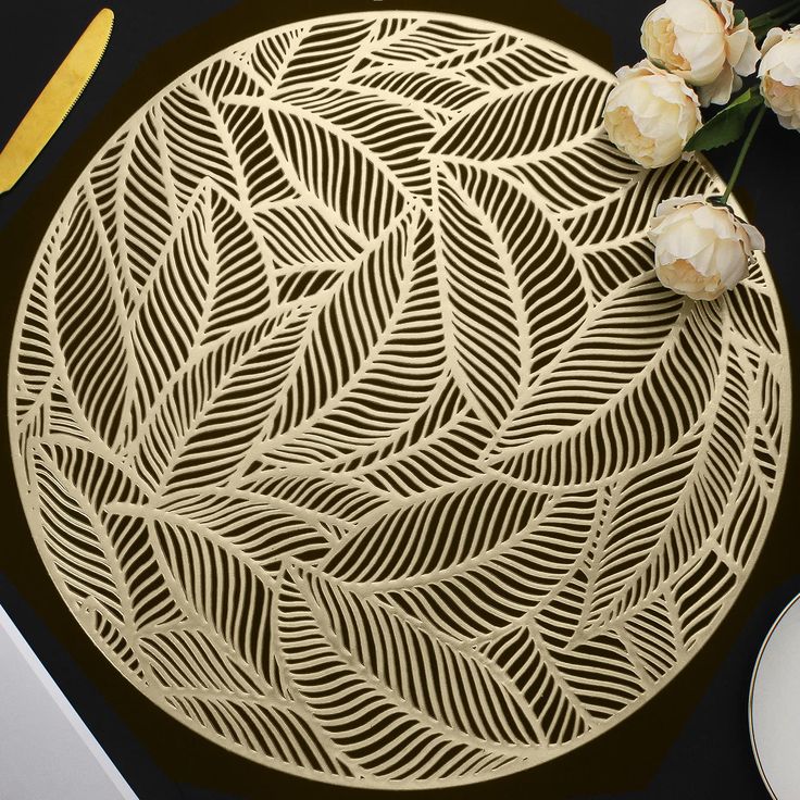 a table with flowers on it next to some plates and utensils in the background