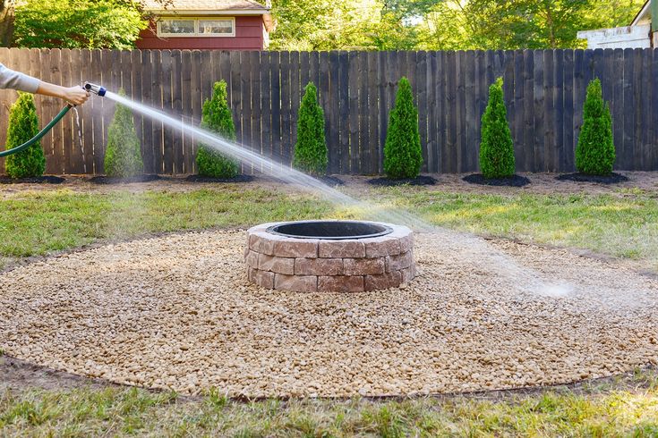 a person is spraying water on a fire pit