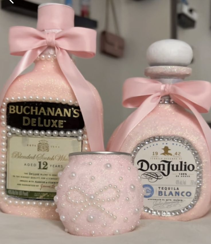 two bottles of boochahan's deluxe with pink bows and pearls on them