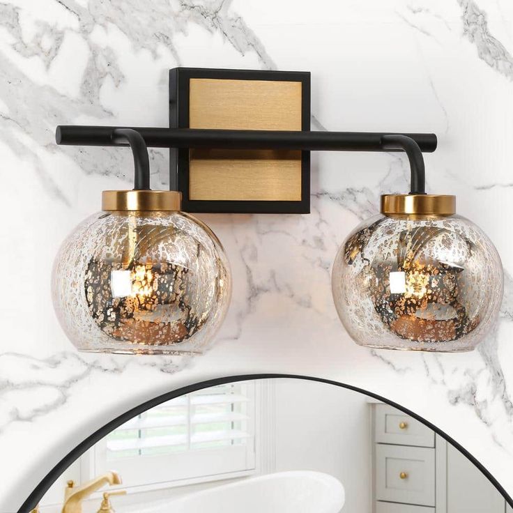 a bathroom with a mirror and two lights on the wall next to a bathtub