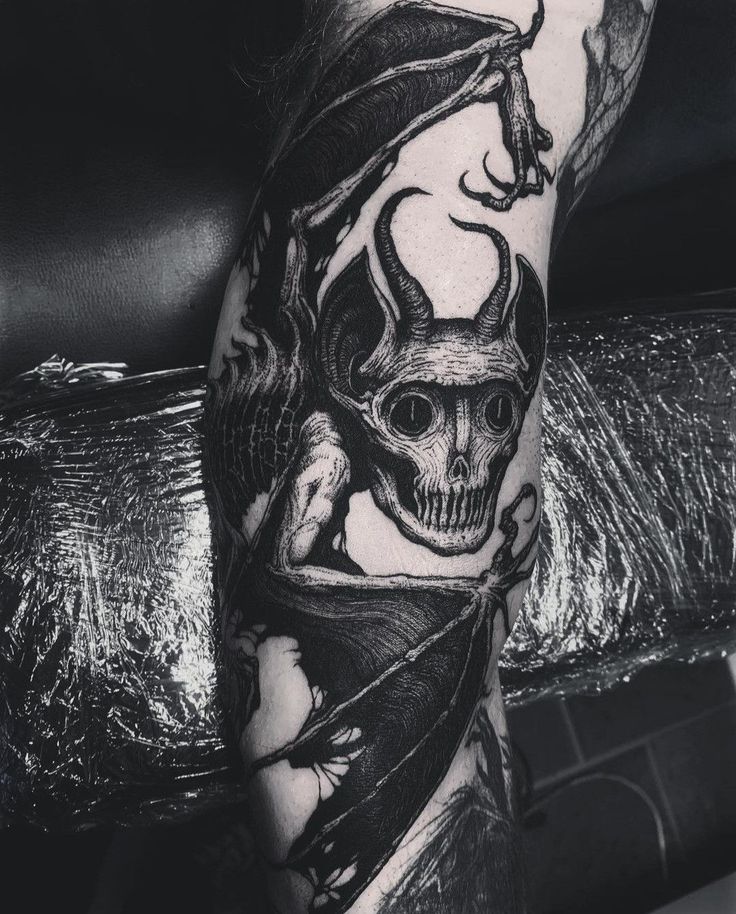 a man's leg with a skull and demon on it